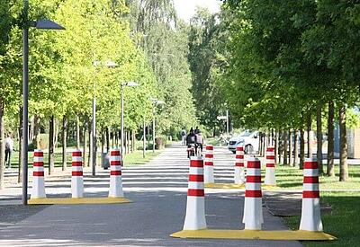 Eine Straße ist mit CitySafe Barrieren so abgeriegelt, dass Fahrzeuge in einem geringem Tempo sie passieren können, zum Beispiel Lieferanten oder Angestellte.